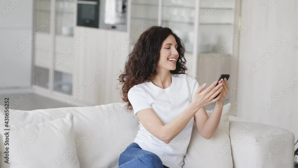 Adult brunette woman with mobile smartphone phone home on sofa happy talking call beautiful brunette model with mobile alone Adult brunette woman with mobile smartphone phone home on sofa happy talking call beautiful brunette model with mobile alone