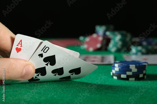 Man playing poker at table with casino chips, closeup. Space for text