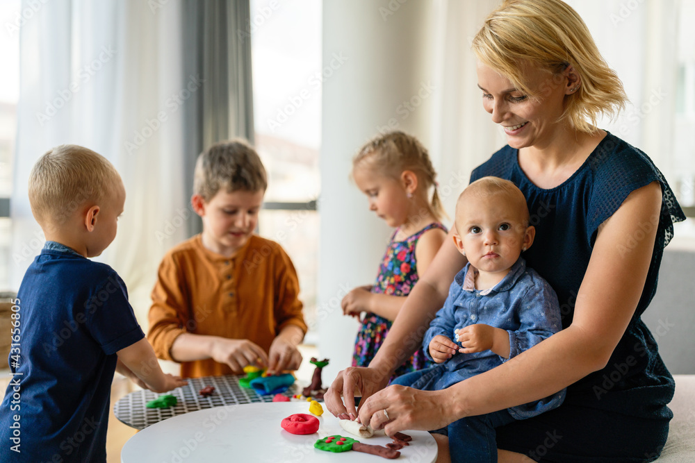 Family activities in the kids room. Woman and children playing together.