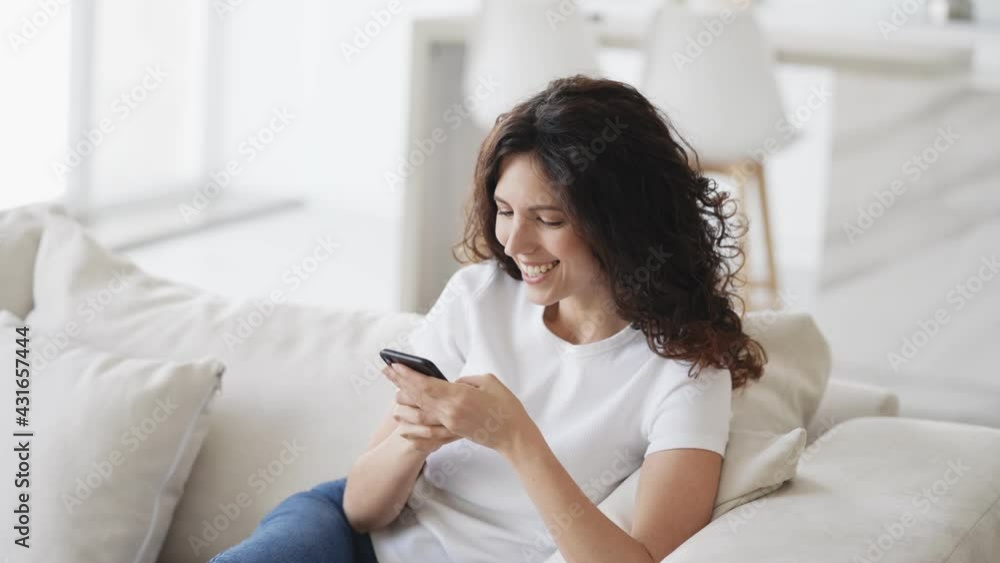 Brunette woman with mobile smartphone home on sofa happy talking call beautiful brunette model with mobile alone Brunette woman with mobile smartphone home on sofa happy talking call beautiful brunette model with mobile alone