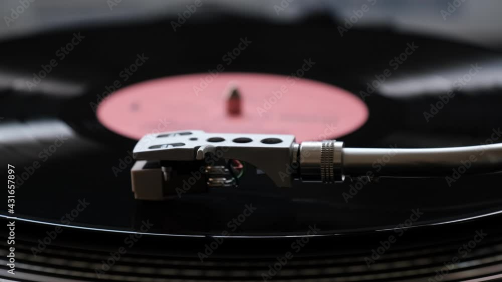 Vinyl record playback. Close up of turntable cartridge and stylus during vinyl record playback. Vinyl record playback. Close up of turntable cartridge and stylus during vinyl record playback.