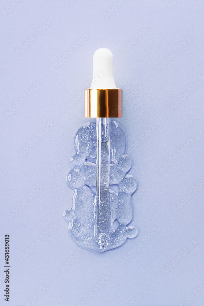 Liquid serum and dropper on a blue background top view. Serum drops in the form of a bottle with a pipette. Liquid serum and dropper on a blue background top view. Serum drops in the form of a bottle with a pipette.