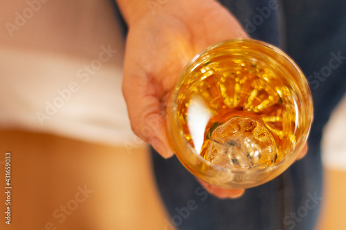 Woman's hand holding a glass of cognac, alcohol concept