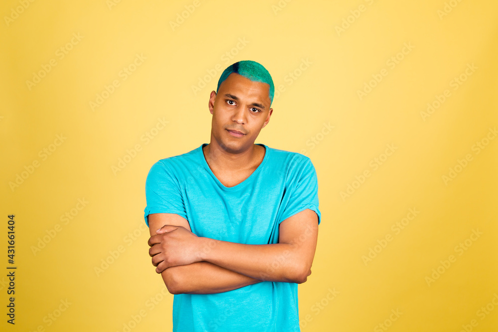 Black african man in casual on yellow background look to camera thoughtful with smile crossed hands arms