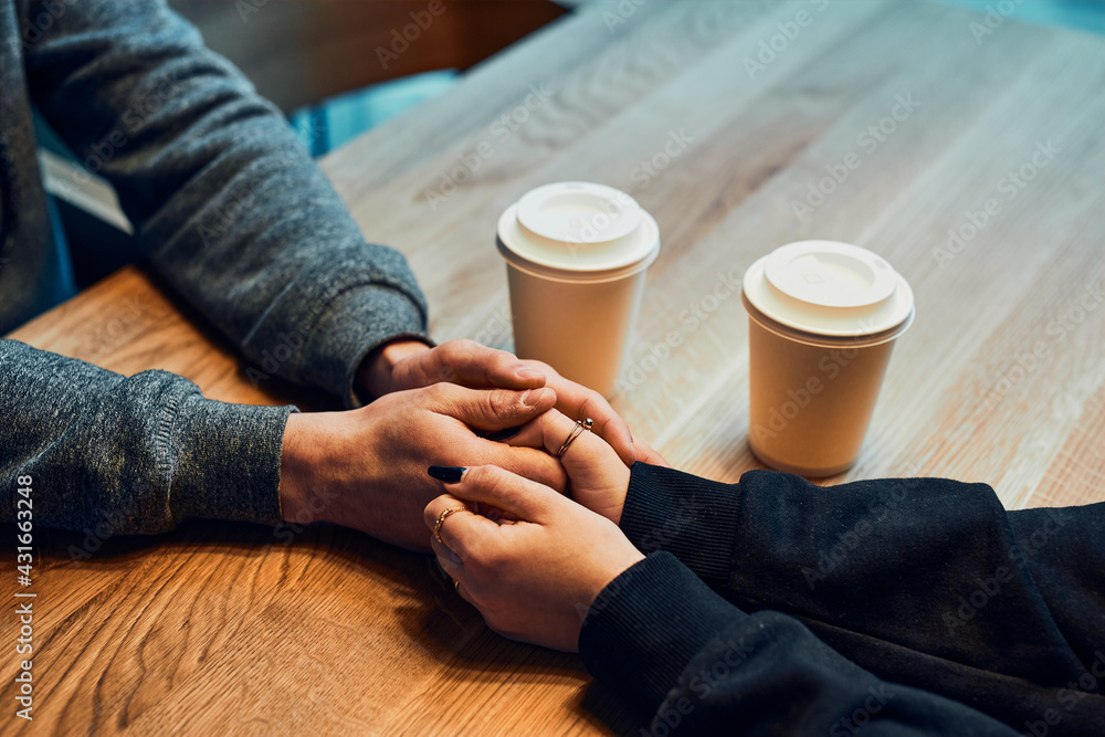 Loving couple holding hands sitting in cafe drinking coffee. Woman and man having a chat, talking together, having a break, relaxing in cafe Loving couple holding hands sitting in cafe drinking coffee. Woman and man having a chat, talking together, having a break, relaxing in cafe