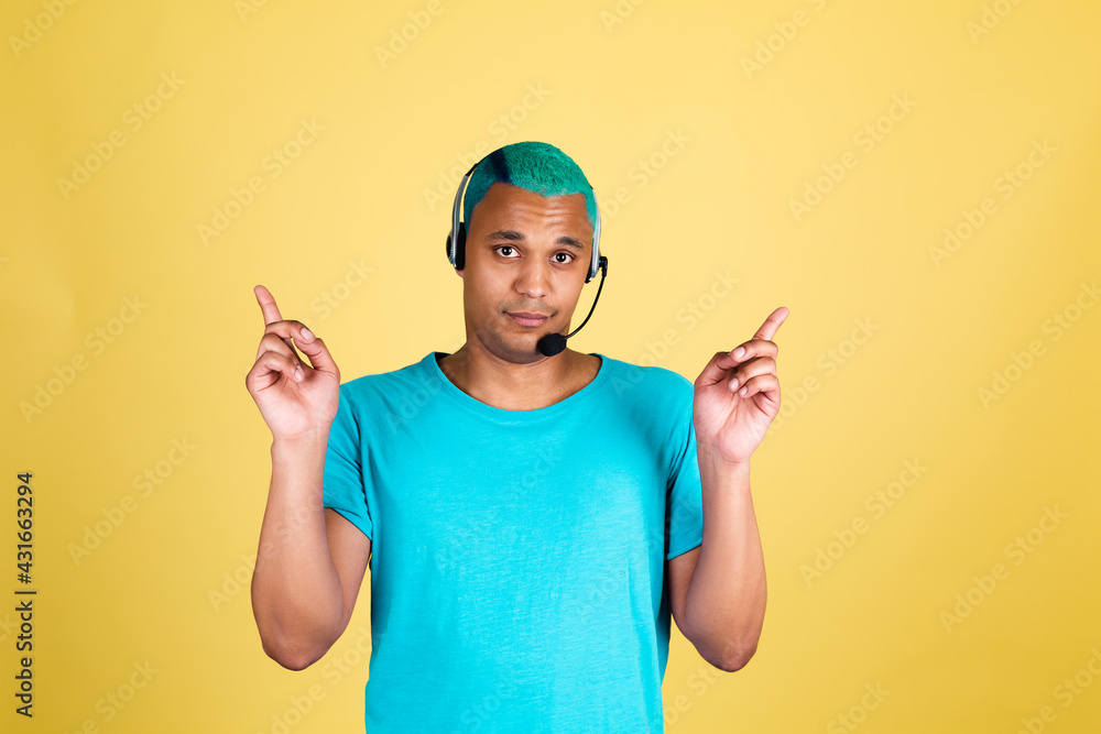 Black african man in casual on yellow background blue hair call centre worker happy customer support operator with headphones point fingers up Black african man in casual on yellow background blue hair call centre worker happy customer support operator with headphones point fingers up