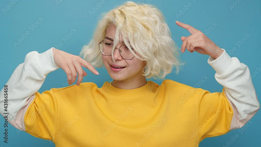 Crazy Shocked Woman Face Asian Girl Showing Emotion Think About it Really Gesture with Index Fingers to Temple of Head on Blue Background. Woman curly blond hair. Emotions People. Lifestyle. Concept Crazy Shocked Woman Face Asian Girl Showing Emotion Think About it Really Gesture with Index Fingers to Temple of Head on Blue Background. Woman curly blond hair. Emotions People. Lifestyle. Concept