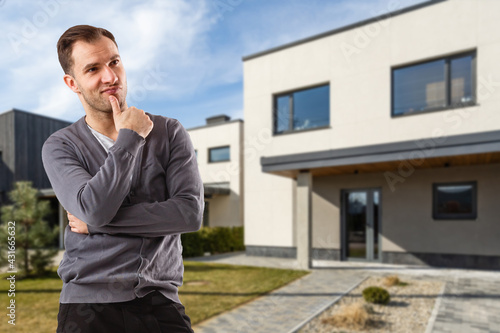Cheerful man standing in front of new house © Angelov