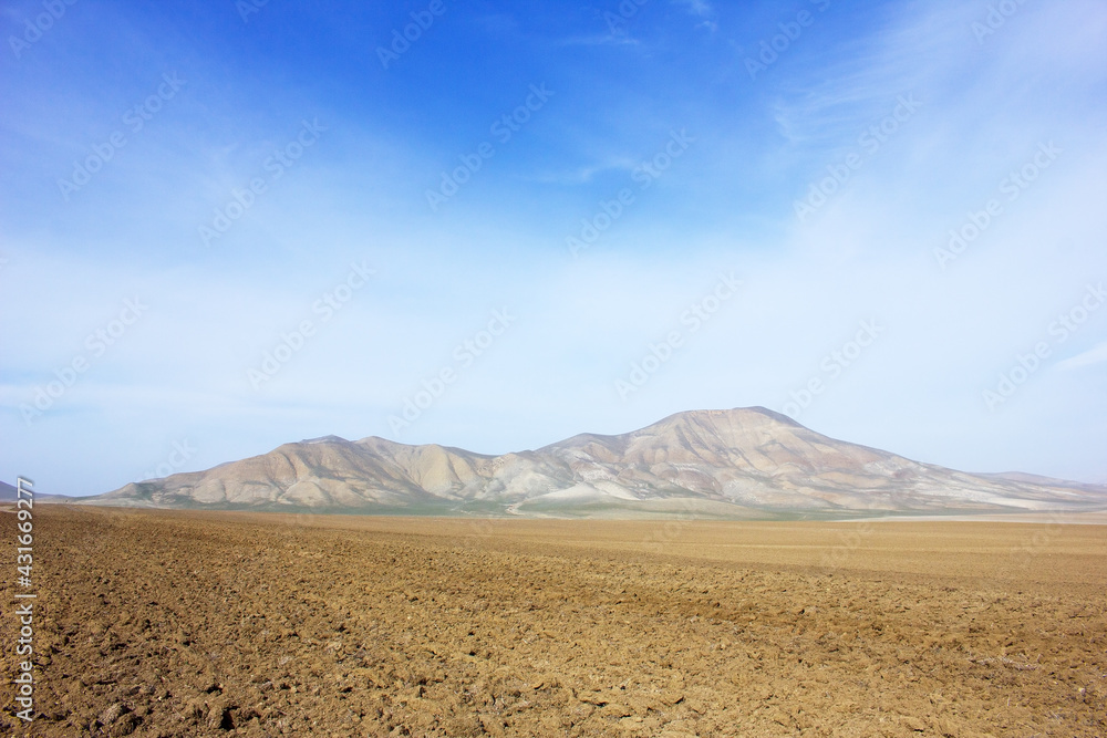 Mountains begin at the end of the field. Gobustan region. Azerbaijan. Mountains begin at the end of the field. Gobustan region. Azerbaijan.