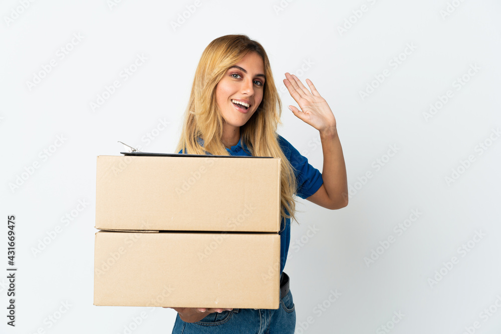 Young blonde Uruguayan delivery woman isolated on white background saluting with hand with happy expression Young blonde Uruguayan delivery woman isolated on white background saluting with hand with happy expression