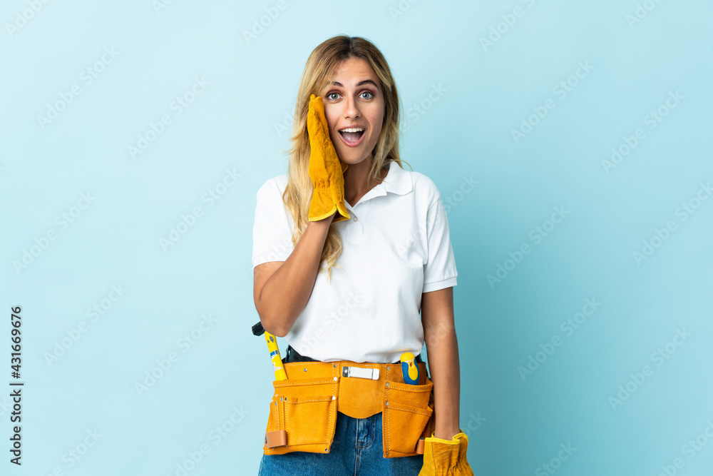 Young blonde Uruguayan electrician woman isolated on blue background with surprise and shocked facial expression Young blonde Uruguayan electrician woman isolated on blue background with surprise and shocked facial expression