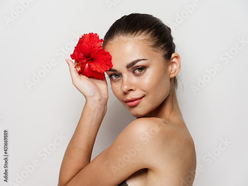 pretty woman with bare shoulders red flower in hands charm