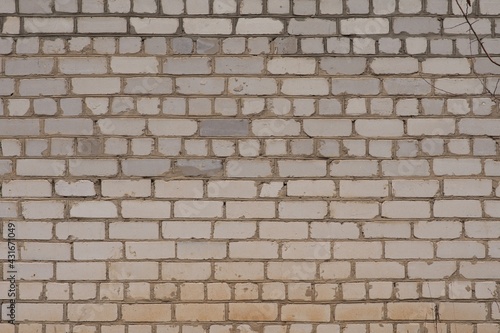 A white old brick wall, yellowed with age. Grunge texture. Brick background.