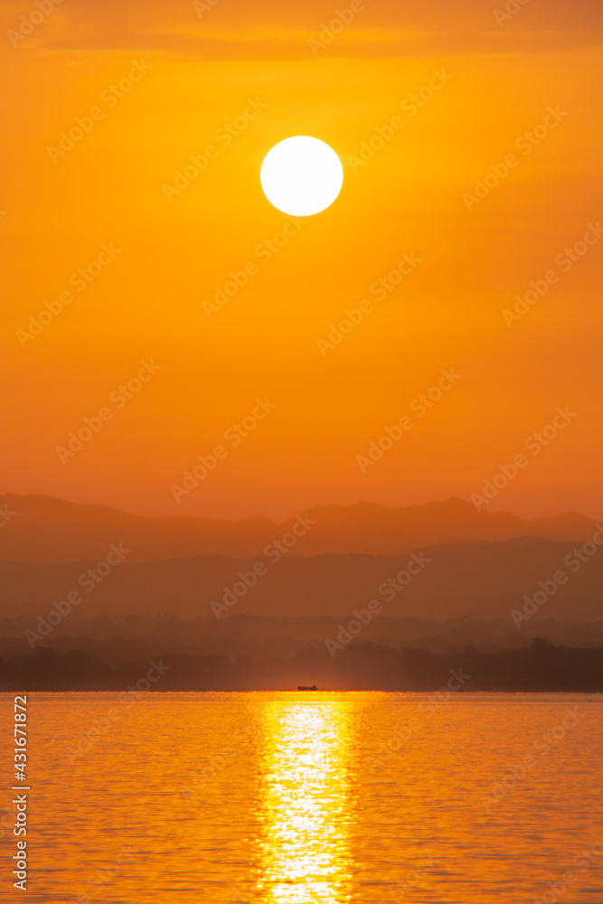 Sunrise over mountain with reflection of sunlight on water. Scenery of Pa Sak Chonlasit reservoir, Lopburi province, Thailand.