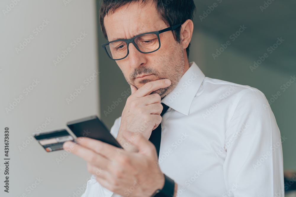 Mobile banking in business office, businessman using smart phone and credit card Mobile banking in business office, businessman using smart phone and credit card