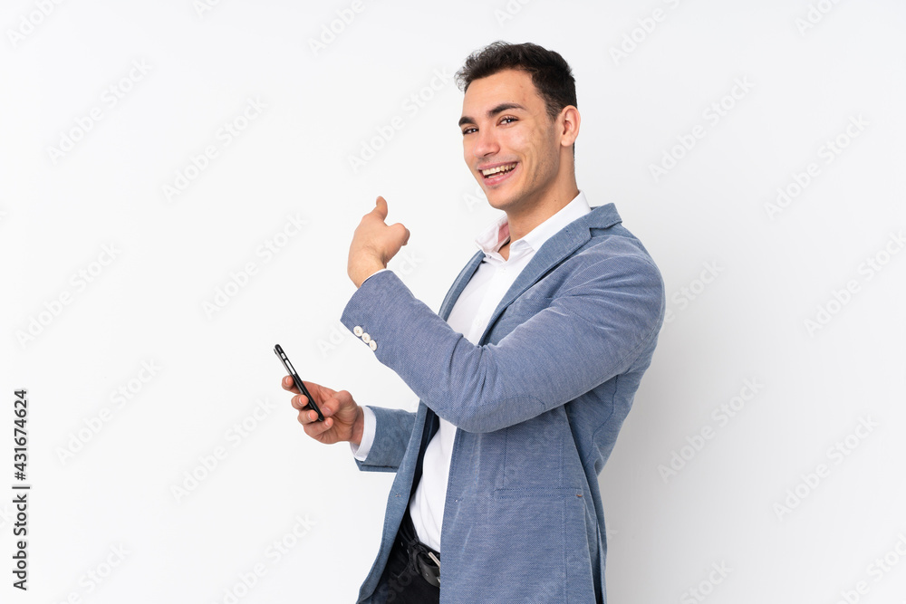 Young handsome businessman on isolated background pointing back Young handsome businessman on isolated background pointing back