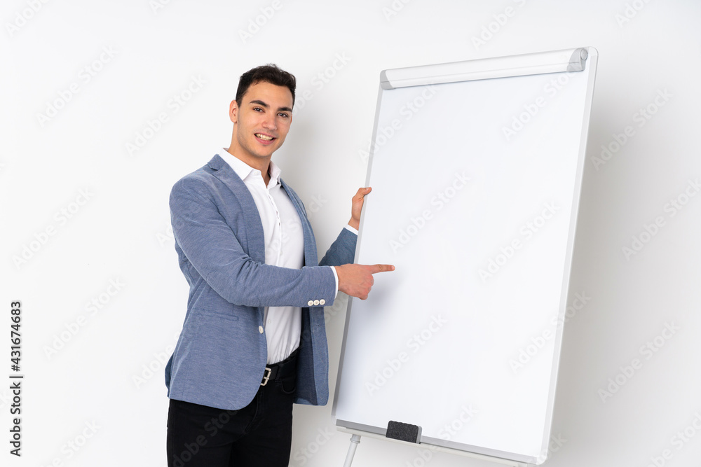 Young caucasian handsome man isolated on purple background giving a presentation on white board and writing in it Young caucasian handsome man isolated on purple background giving a presentation on white board and writing in it