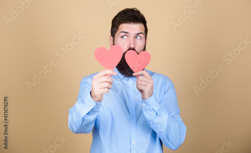 Love matters. Romantic love celebration. Bearded man holding red hearts. Hipster with small hearts. Sexy valentine man with heart shaped cards. Happy valentines day