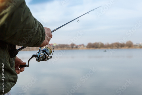 Fishing on the lake at sunset. Fisherman with rod, spinning reel on the river bank. Sunrise. Fishing for pike, perch, carp. Fog against the backdrop of lake.wild nature.