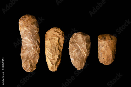 four stone age neolithic adzes. Belonging to the Acheulean culture. Handle tools. Of flint. used for manual digging. located in the sahara desert. Black background photo