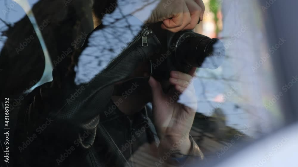 Paparazzi or detective secretly photographing something while sitting in the car. Collecting compromising evidence or material for an article Paparazzi or detective secretly photographing something while sitting in the car. Collecting compromising evidence or material for an article