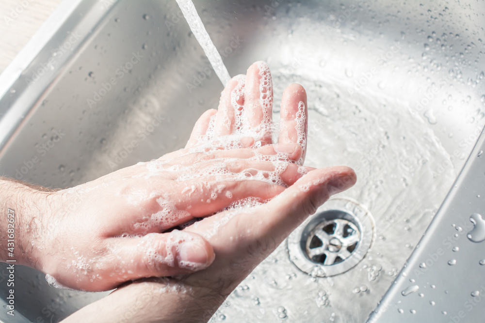 Male Soaping His Hands Next To Pouring Water At A Kitchen Sink Male Soaping His Hands Next To Pouring Water At A Kitchen Sink