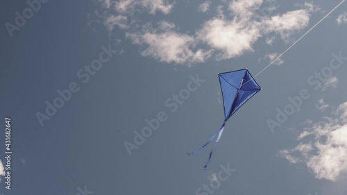 A blue kite soars in the sky. The concept of freedom, summer hobbies, entertainment in nature. Minimalism, space for text, shades of blue.	
 photo