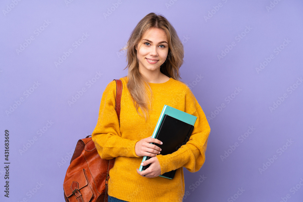 © luismolinero - Teenager Russian student girl isolated on purple background keeping the arms crossed in frontal position