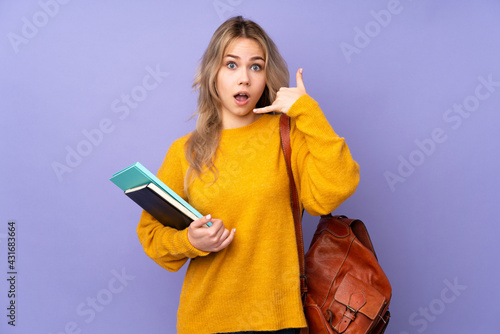 Teenager Russian student girl isolated on purple background making phone gesture and doubting