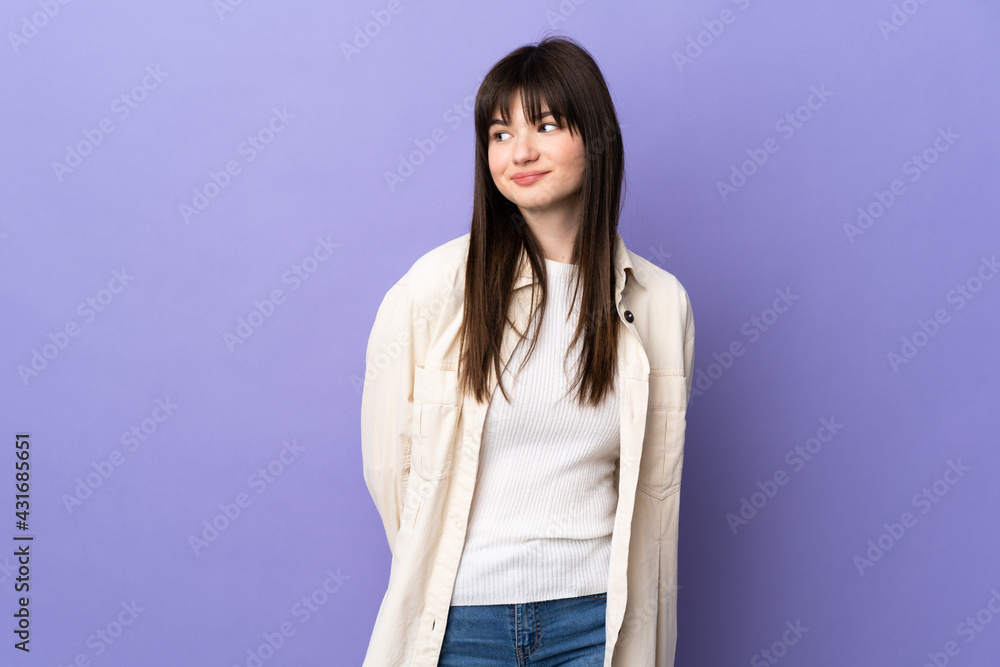 Young Ukrainian woman isolated on purple background making doubts gesture looking side Young Ukrainian woman isolated on purple background making doubts gesture looking side