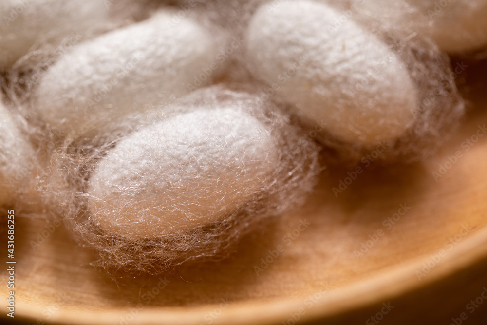 Close-up of silkworm cocoons in wooden dish. Silk close-up. Close-up of silkworm cocoons in wooden dish. Silk close-up.