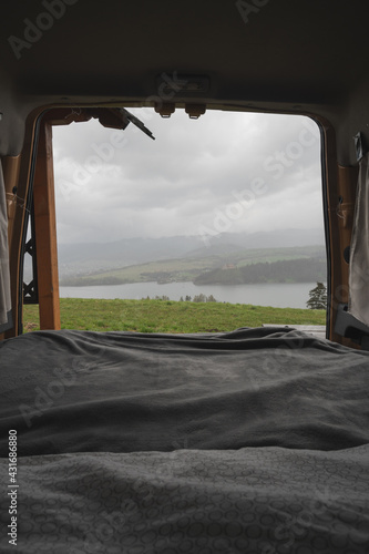 Views from a camper van of the mountains and lakes of Falsztyn poland near the Pieniny nature park. Bed in a camper van, cosy house on wheels, mientras llueve fuera.