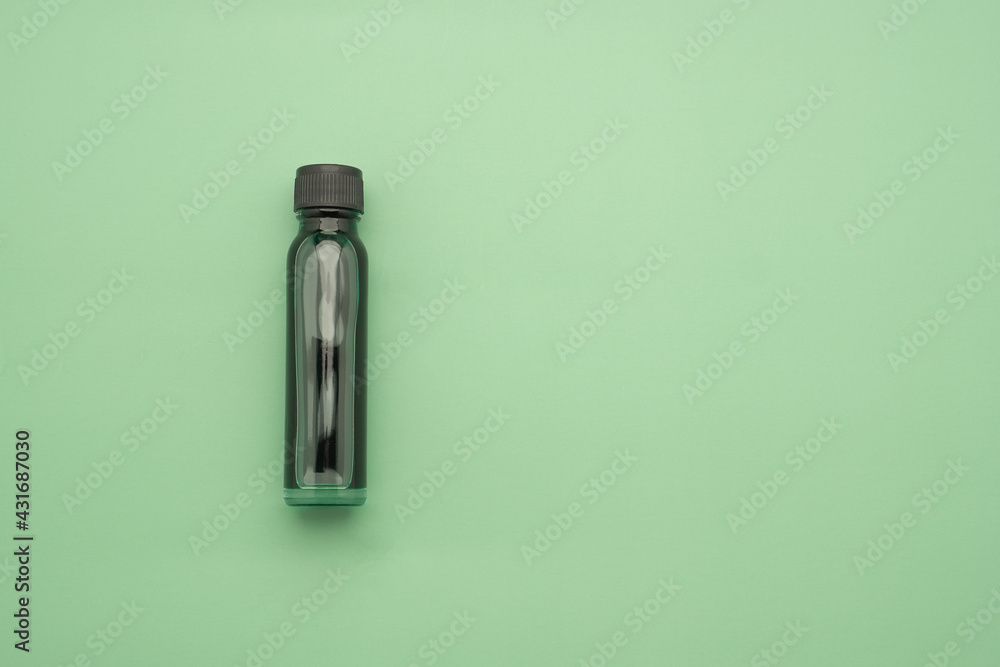 Essential oils in a bottle placed on a green background. Space for text. Top view photo