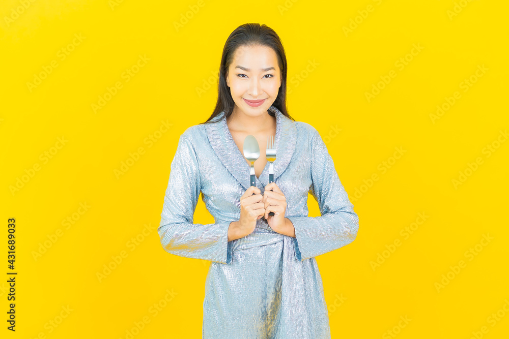 Portrait beautiful young asian woman smile with spoon and fork Portrait beautiful young asian woman smile with spoon and fork