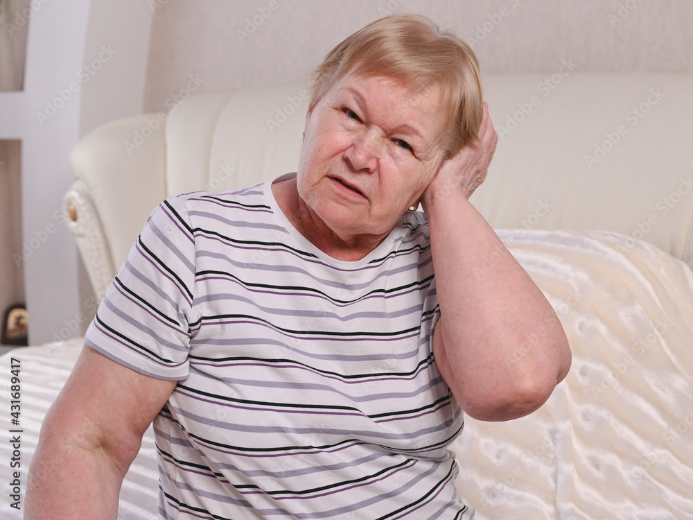 Elderly woman on bed with ear pain Elderly woman on bed with ear pain