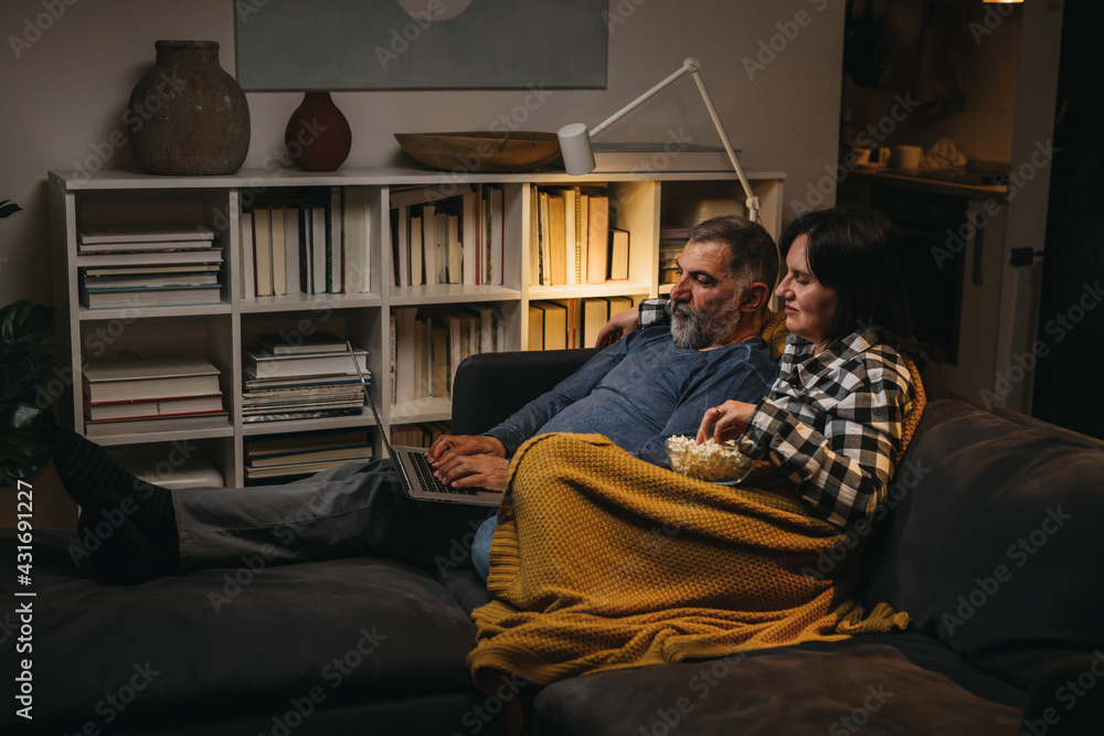 couple relaxing at home using laptop.night scene couple relaxing at home using laptop.night scene