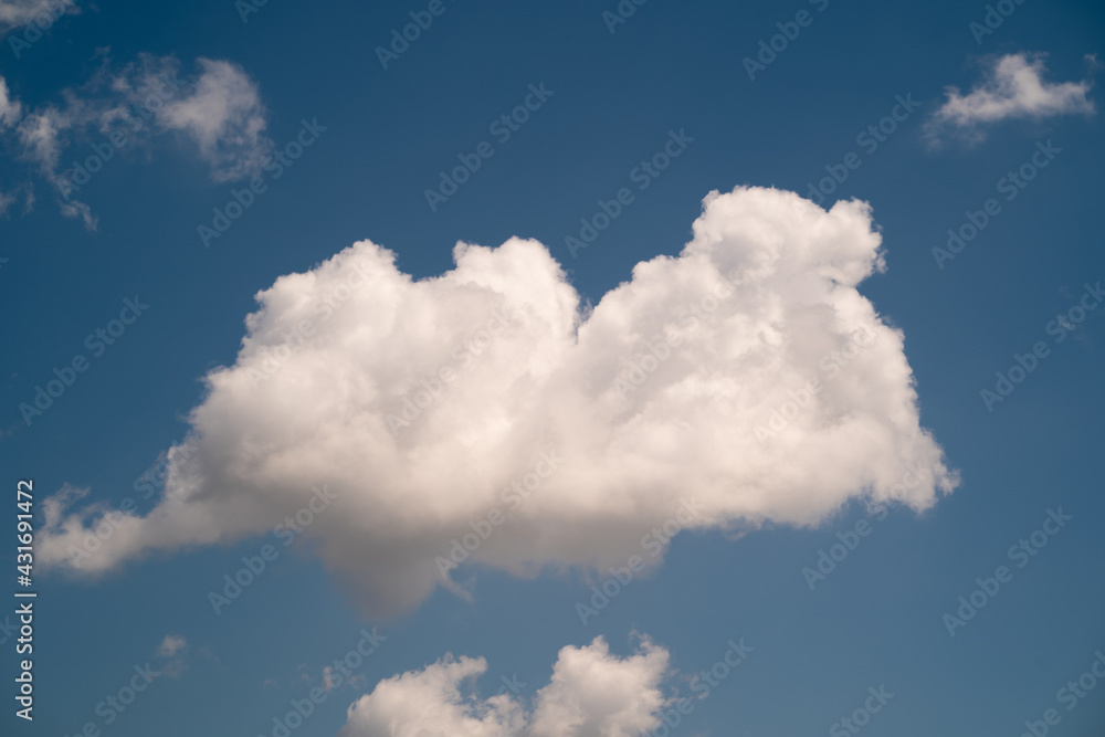 Obraz premium Puffy white cloud on a blue sky background.