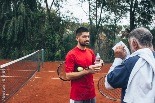 father and son talking after tennis game