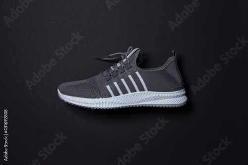 Gray sneakers on a black background. Sports shoes. Healthy lifestyle concept