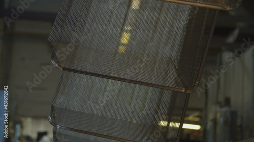 Wired mesh cages moving on the track in the factory