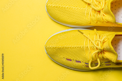 Yellow sneakers on a yellow background. Sports shoes. Healthy lifestyle concept