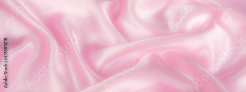 Abstract pink silk fabric texture background. Cloth soft wave. Creases of satin