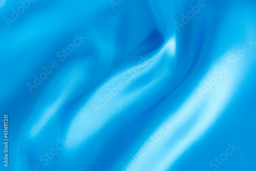 Abstract blue silk fabric texture background. Cloth soft wave. Creases of satin