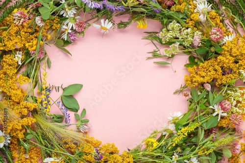 Beautiful wreath of wild flowers , typical Scandinavian midsummer decoration concept. Pink background. Top view