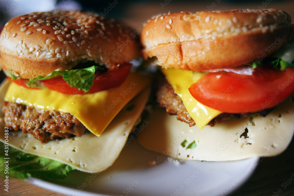 Photos of homemade burgers. Steak and white bun with sesame seeds, cheese and cabbage, tomatoes. Homemade food. Photos of homemade burgers. Steak and white bun with sesame seeds, cheese and cabbage, tomatoes. Homemade food.
