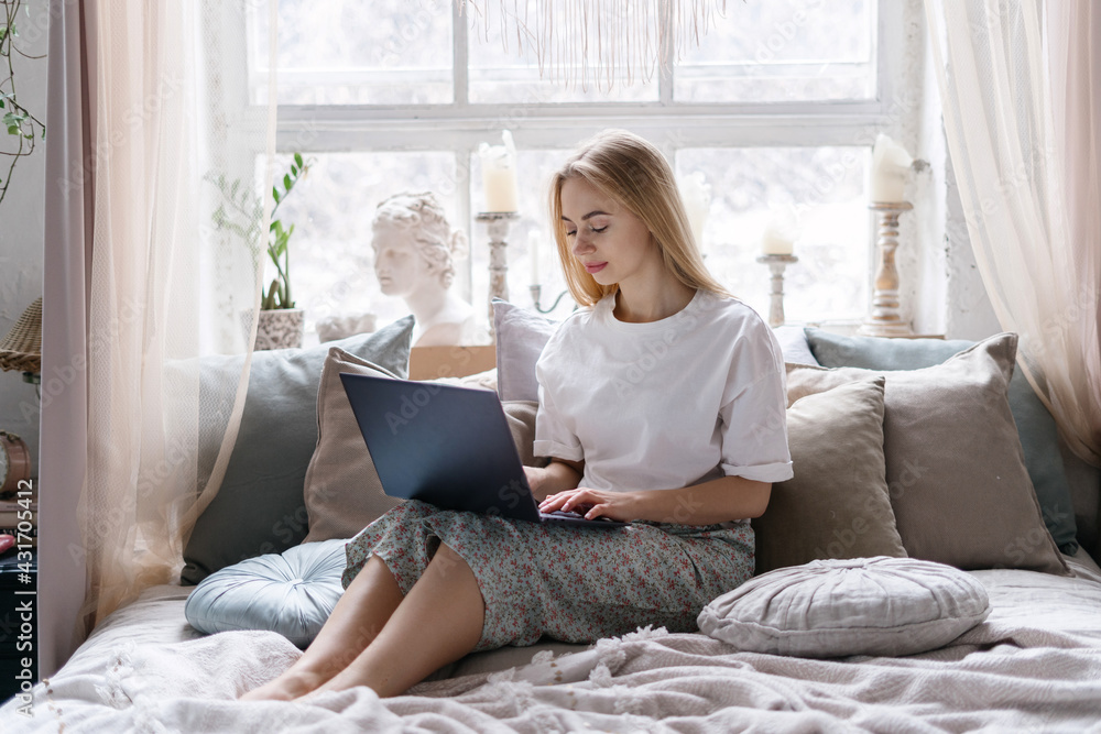Young woman in pajamas using modern laptop Young woman in pajamas using modern laptop