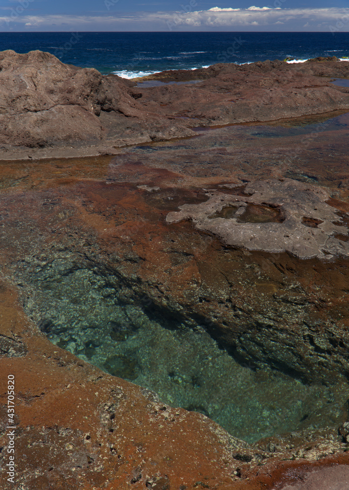 Obraz premium Gran Canaria, calm natural seawater pools in under the steep cliffs of the north coast, separated from the ocean by volcanic rock, Punta de Galdar area