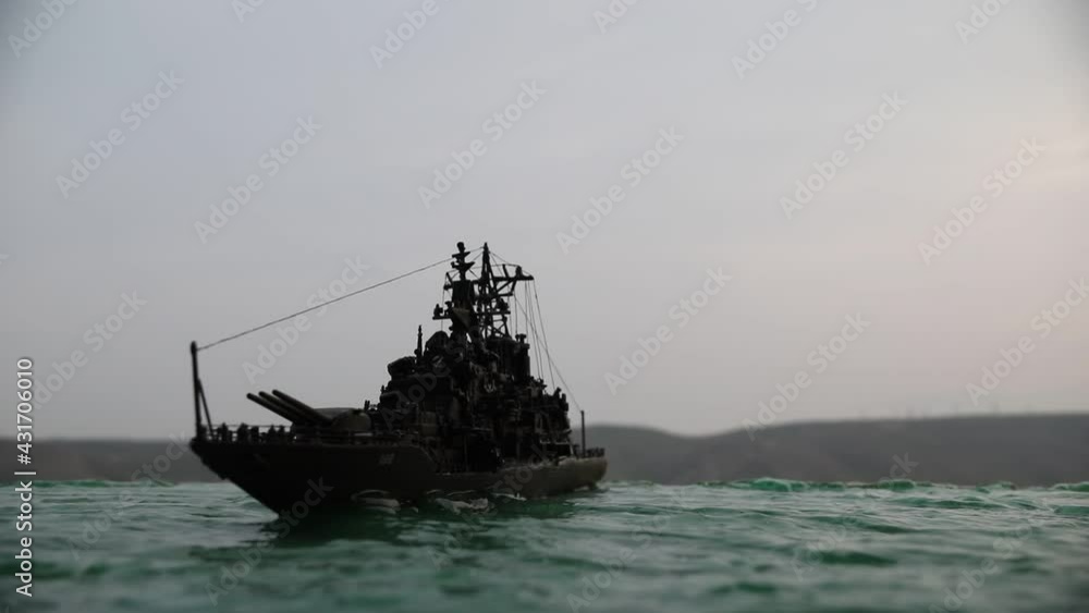 War concept. Night battle scene at sea. Dramatic toned clouds effect. Silhouette of the battle ship at sunset. Miniature creative table decoration. Selective focus War concept. Night battle scene at sea. Dramatic toned clouds effect. Silhouette of the battle ship at sunset. Miniature creative table decoration. Selective focus