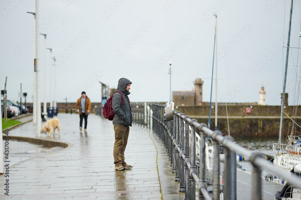 Tourist exploring Whitehaven harbour in Cumbria, England, UK.