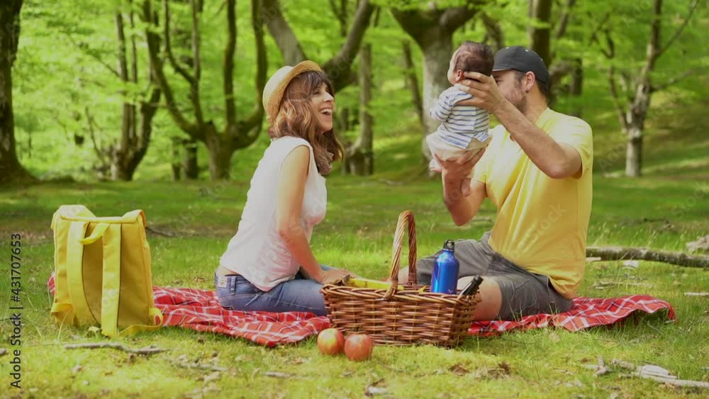 A family on a picnic day playing with their newborn son. With yellow, white t-shirts and hats, summer lifestyle on vacation A family on a picnic day playing with their newborn son. With yellow, white t-shirts and hats, summer lifestyle on vacation